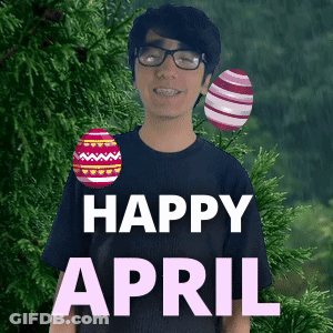 A Man With Glasses And Braces Is Standing In Front Of A Tree With Easter Eggs And The Words Happy April GIF