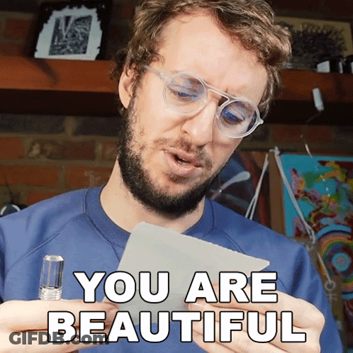 A Man With Glasses Holds A Piece Of Paper That Says " You Are Beautiful " GIF