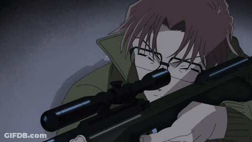 A Man With Glasses Holds A Sniper Rifle In His Hand GIF