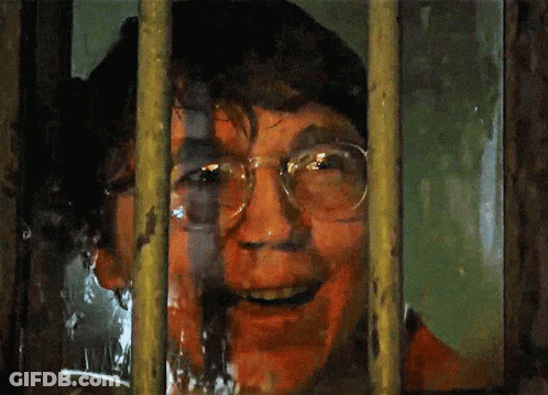 A Man With Glasses Is Behind Bars With His Mouth Open GIF