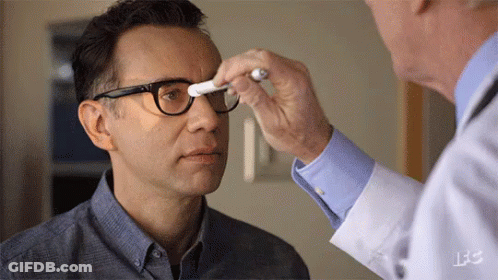 A Man With Glasses Is Being Examined By A Doctor GIF