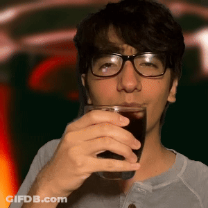 A Man With Glasses Is Drinking A Glass Of Soda GIF