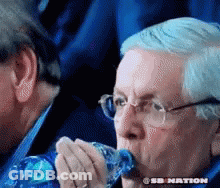 A Man With Glasses Is Drinking From A Plastic Bottle .. GIF