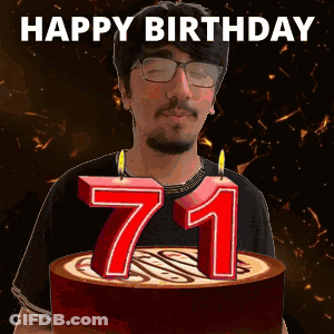 A Man With Glasses Is Holding A Cake With Candles In The Shape Of The Number 71 GIF