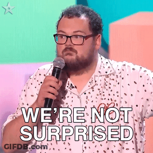 A Man With Glasses Is Holding A Microphone And Saying We 'Re Not Surprised . GIF
