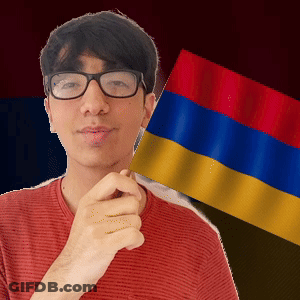 A Man With Glasses Is Holding A Small Flag GIF