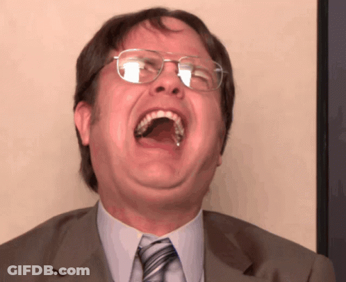 A Man With Glasses Is Laughing With His Mouth Open GIF