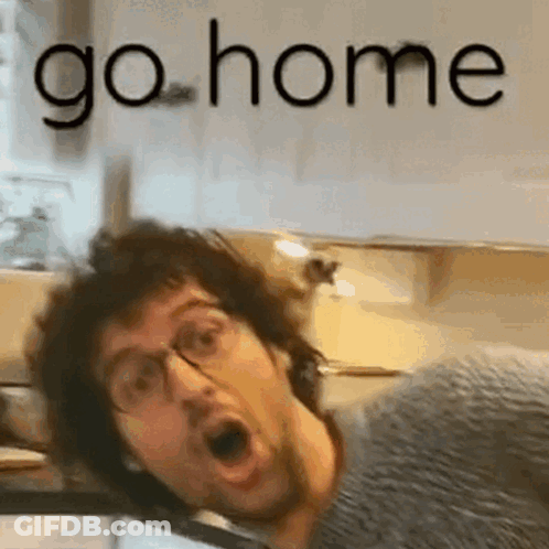 A Man With Glasses Is Making A Funny Face In A Kitchen With The Words `` Go Home '' Behind Him . GIF