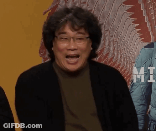 A Man With Glasses Is Making A Funny Face In Front Of A Poster That Says Mt. GIF