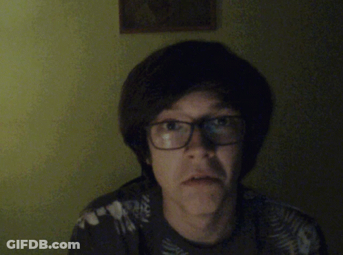 A Man With Glasses Is Pointing At The Camera And Smiling GIF