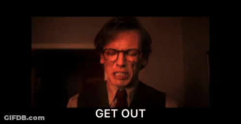 A Man With Glasses Is Screaming In A Dark Room With The Words Get Out Above Him GIF