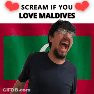 A Man With Glasses Is Screaming In Front Of A Flag That Says Scream If You Love Maldives GIF