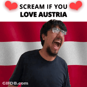 A Man With Glasses Is Screaming In Front Of An Austrian Flag GIF