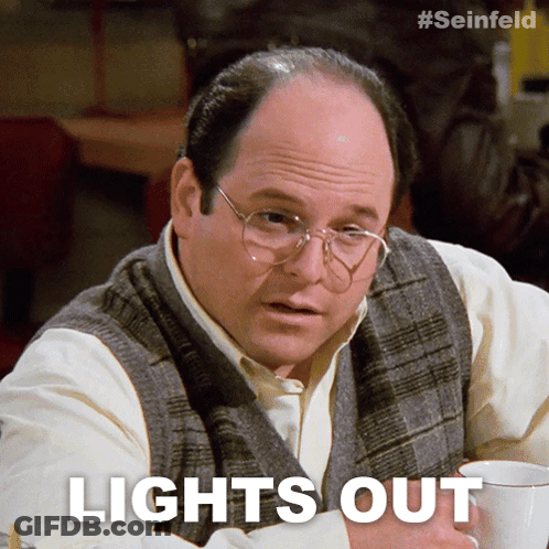 A Man With Glasses Is Sitting At A Table With A Cup Of Coffee And The Words Lights Out Above Him GIF