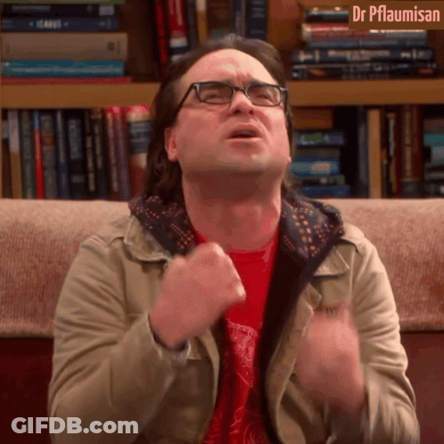 A Man With Glasses Is Sitting On A Couch In Front Of A Bookshelf With Dr Pflaumisan Written On The Top GIF
