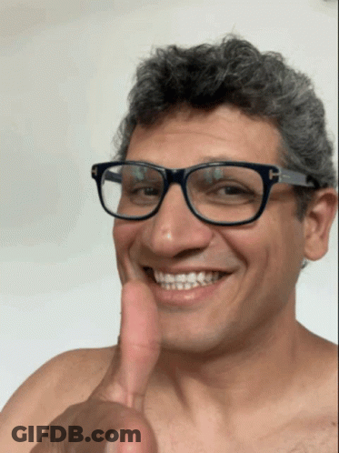 A Man With Glasses Is Smiling And Giving A Thumbs Up GIF