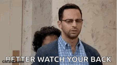 A Man With Glasses Is Standing Next To Another Man With A Beard And Says `` Better Watch Your Back '' . GIF