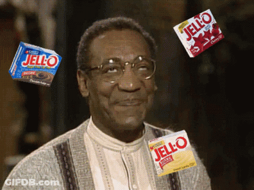 A Man With Glasses Is Surrounded By Jello Boxes GIF