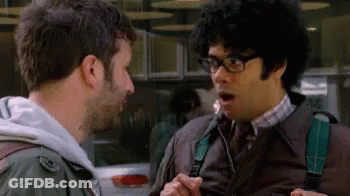 A Man With Glasses Is Talking To Another Man With A Surprised Look On His Face GIF