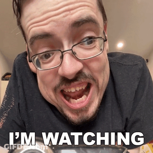 A Man With Glasses Says I 'M Watching With His Mouth Open GIF