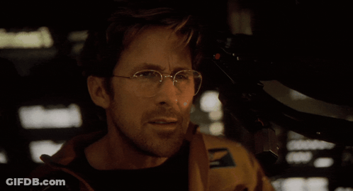 A Man With Glasses Says " They Think I 'M Dumb " In A Dark Room GIF