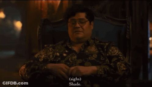 A Man With Glasses Sits In A Chair And Says " Sighs " And " Shade " GIF