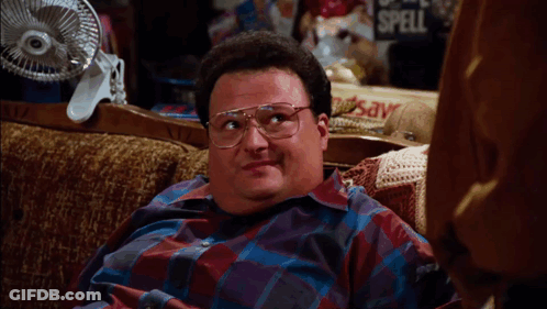 A Man With Glasses Sits On A Couch With The Words I Need A Really Pretty Face Above Him GIF
