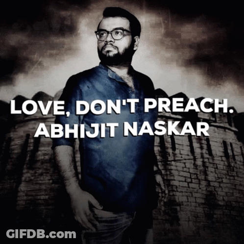 A Man With Glasses Stands In Front Of A Brick Wall With The Words Love Do N't Preach Abhijit Naskar GIF