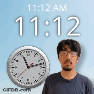 A Man With Glasses Stands In Front Of A Clock That Reads 11:12 GIF