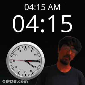A Man With Glasses Stands In Front Of A Clock That Reads 4:15 GIF