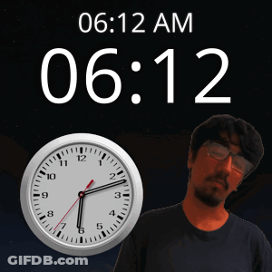 A Man With Glasses Stands In Front Of A Clock That Says 06.12 Am GIF