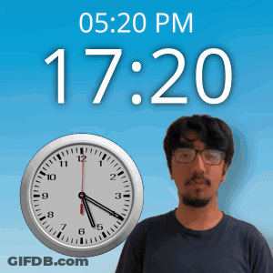 A Man With Glasses Stands In Front Of A Clock That Says 17:20 Pm GIF