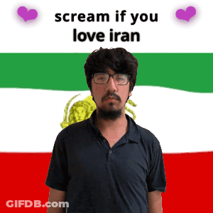 A Man With Glasses Stands In Front Of A Flag That Says Scream If You Love Iran On It GIF