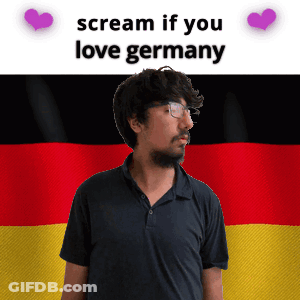 A Man With Glasses Stands In Front Of A German Flag With The Words Scream If You Love Germany GIF