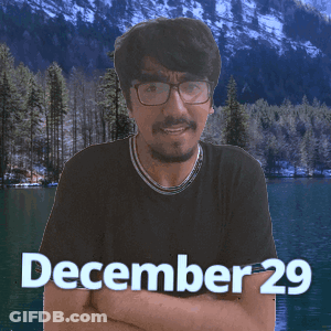 A Man With Glasses Stands In Front Of A Lake With The Date December 29 On The Bottom GIF