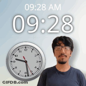 A Man With Glasses Stands In Front Of A Wall Clock That Says 09:28 Am GIF