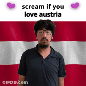 A Man With Glasses Stands In Front Of An Austria Flag GIF