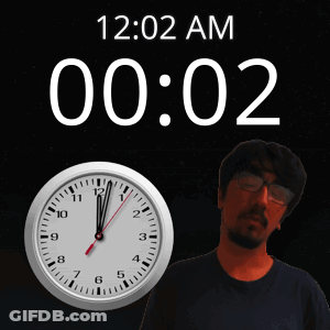A Man With Glasses Stands Next To A Clock That Says 12:02 Am GIF