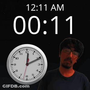 A Man With Glasses Stands Next To A Clock That Says 12:11 Am GIF