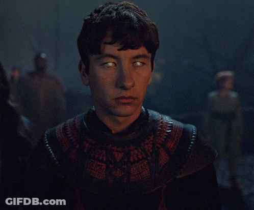 A Man With Glowing Green Eyes Is Wearing A Black And Red Sweater GIF
