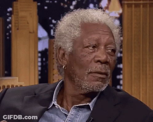 A Man With Gray Hair And A Beard Is Wearing A Black Suit GIF