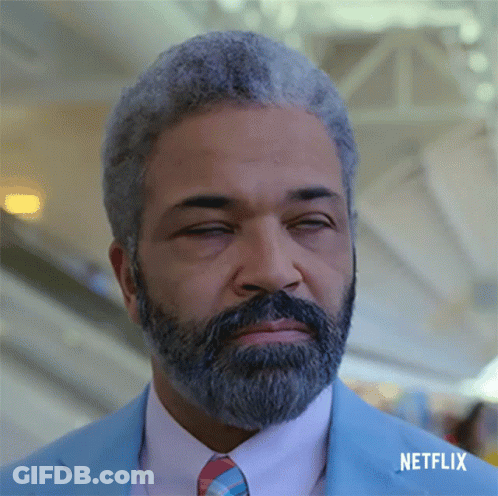 A Man With Gray Hair And A Beard Is Wearing A Blue Suit And Tie With Netflix Written Below Him GIF