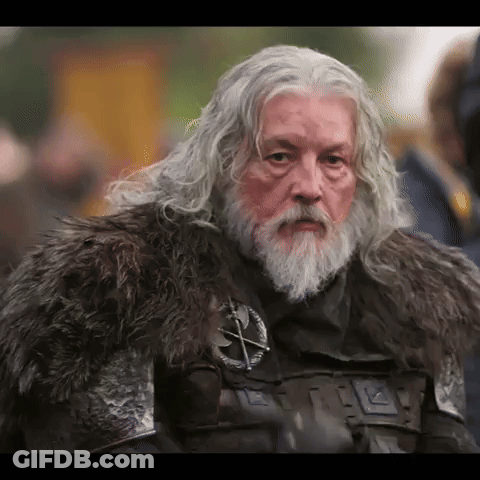 A Man With Gray Hair And A Beard Wearing A Fur Coat GIF