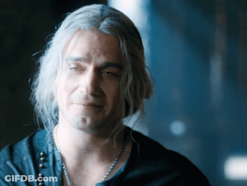 A Man With Gray Hair And A Necklace Looks Down GIF