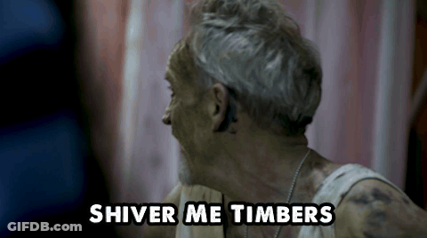 A Man With Gray Hair And A White Tank Top Says Shiver Me Timbers GIF