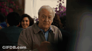 A Man With Gray Hair Is Sitting In Front Of A Window GIF