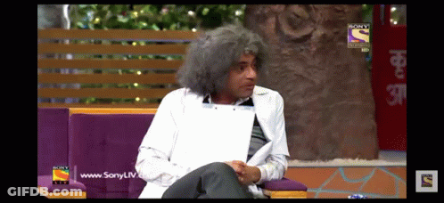 A Man With Gray Hair Is Sitting On A Couch In Front Of A Sony Tv Screen GIF
