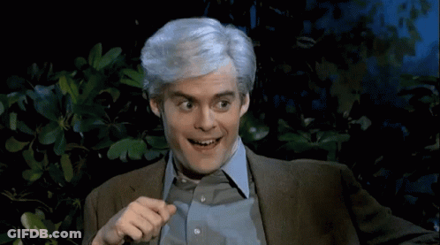 A Man With Gray Hair Is Smiling And Pointing At Something GIF