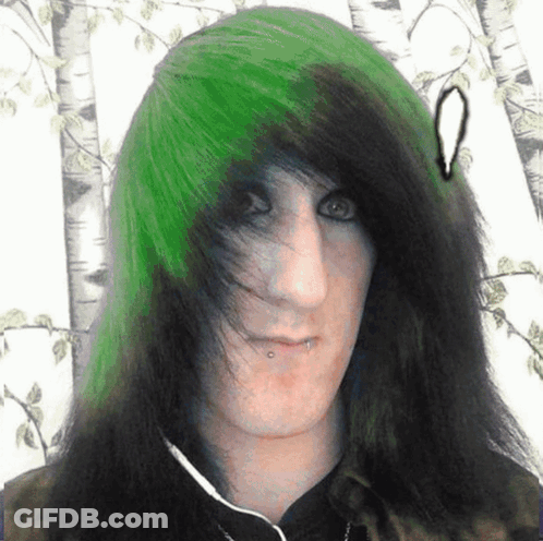 A Man With Green And Black Hair Has A Piercing In His Nose GIF