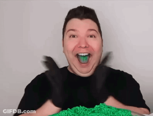 A Man With Green Frosting On His Tongue And Black Gloves On His Hands GIF